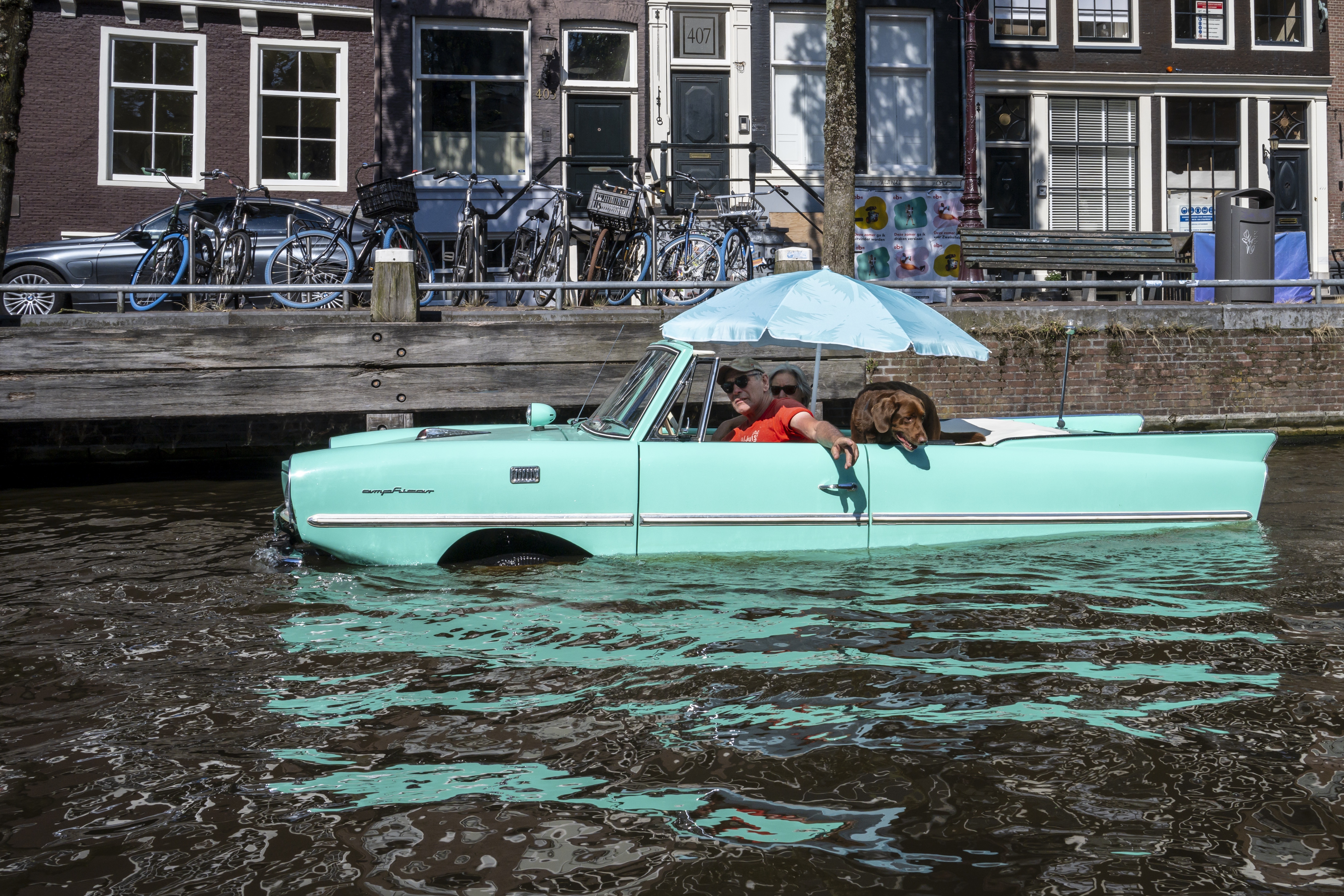 Auto in het water langs de kade