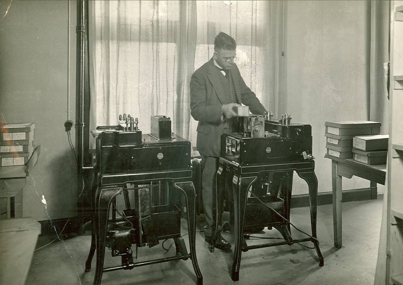 Employee operates a large machine to process punch cards