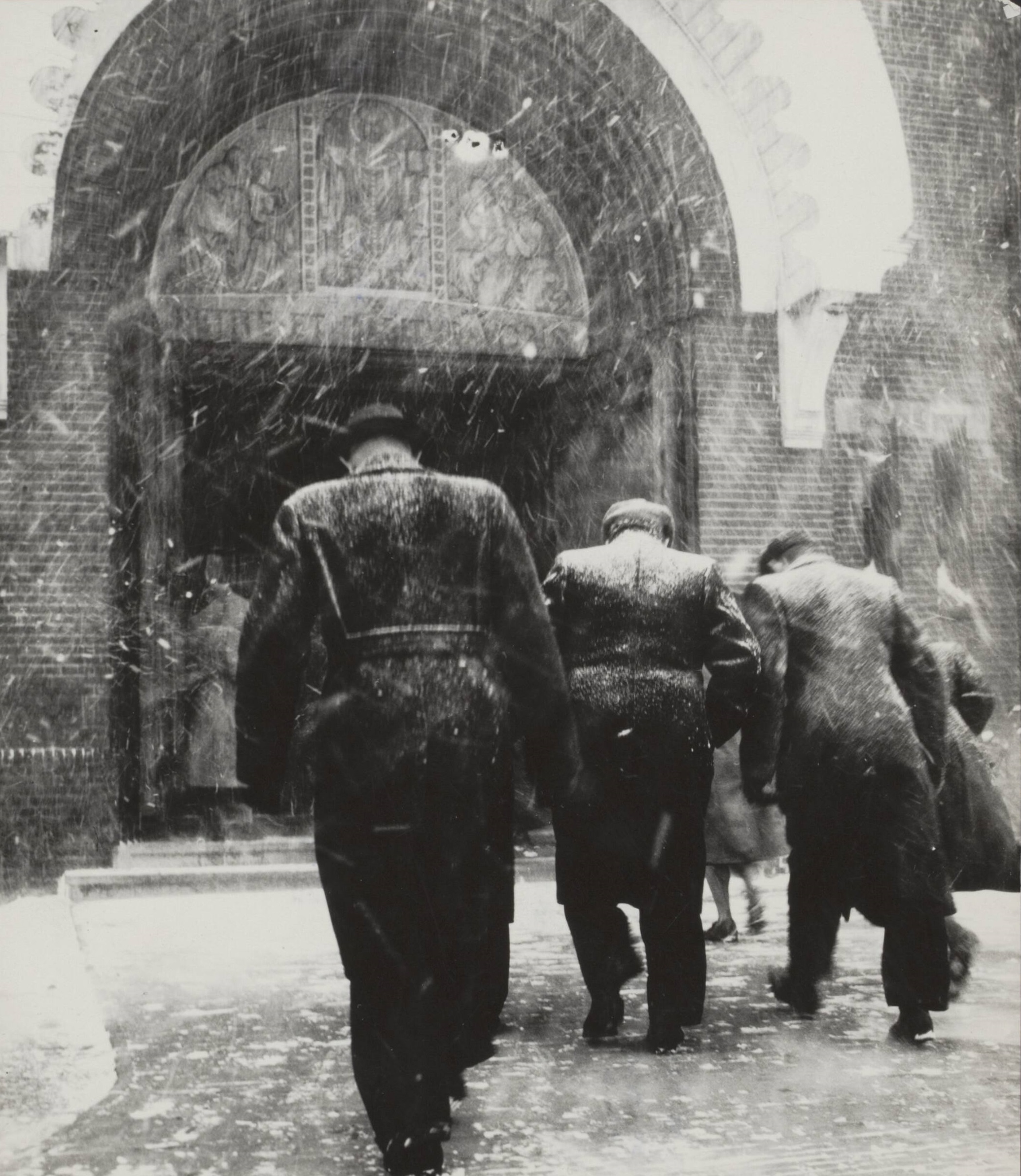 1953 - Herdenkingszondag Watersnood 1953. Met gebogen hoofden door opnieuw storm en regen lopen de kerkgangers naar de kerk te Halsteren