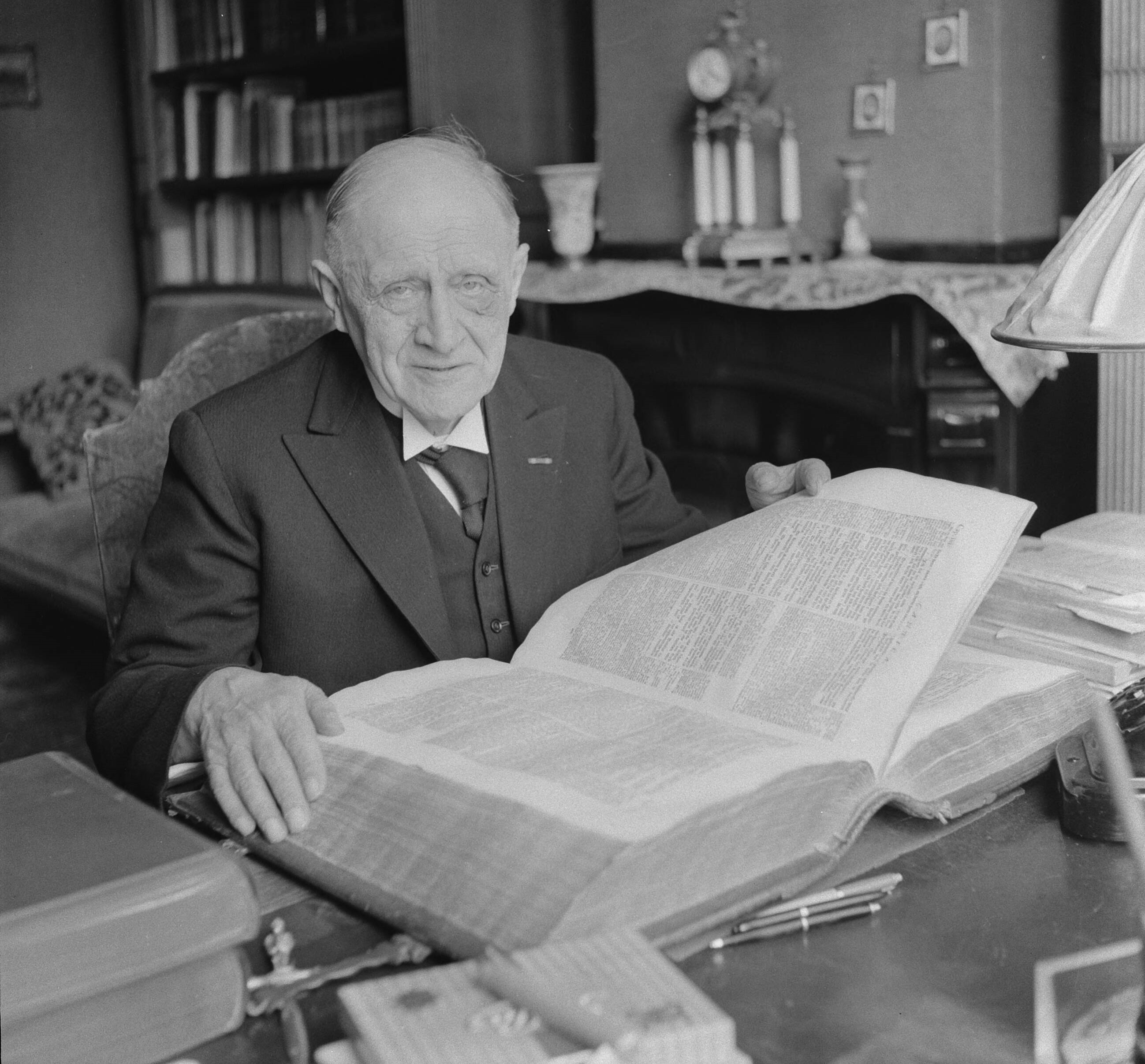1960 - Pieter Zandt was een Nederlands politicus en predikant en leest in een grote bijbel. Van 1925 tot 1961 kamerlid voor de SGP (bron Wikipedia)